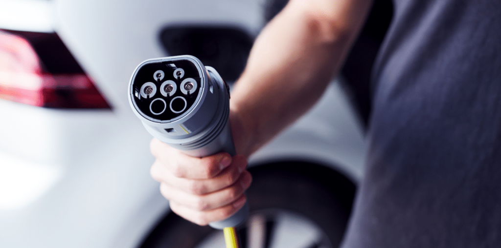 Man holding an electric car charger